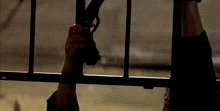 a person holding a gun behind a fence in a dark room