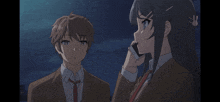 a girl talking on a cell phone next to a boy in a suit and tie