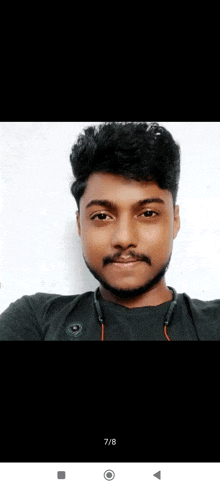 a young man with a beard and mustache is taking a selfie