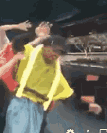 a man wearing a yellow vest is dancing in front of a truck