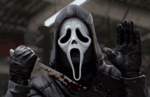 a person wearing a scream mask is holding a knife