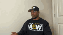 a man wearing glasses and a black aew wrestling shirt
