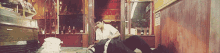 a man laying on the floor in front of a sign that says ' bakery ' on it