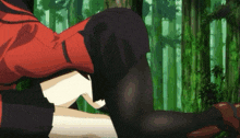 a woman in a red jacket is laying on a man 's lap in the woods