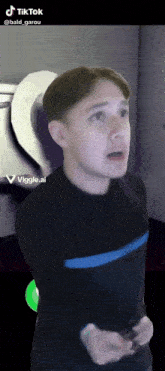 a man in a black shirt with a blue stripe on the sleeves is standing in front of a sign that says tik tok