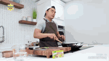 a man in an apron is cooking in a kitchen with a knorr box on the counter