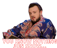 a man in a blue and red paisley robe says " you know nothing jon snow "