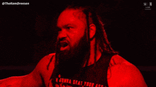 a man with dreadlocks is wearing a shirt that says i 'm gonna beat your ass