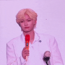 a man with blonde hair is holding a microphone and crying