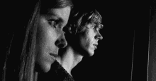 a man and a woman are standing next to each other in a dark room .