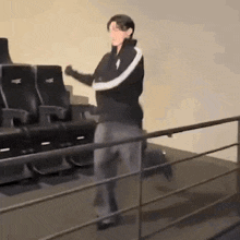 a man is standing in front of a railing in a movie theater .