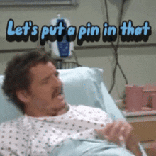 a man is laying in a hospital bed with the words let 's put a pin in that above him