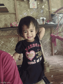 a little girl wearing a shirt that says ' sweet at heart ' on it
