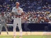 a baseball player with the letter t on his jersey stands on the field