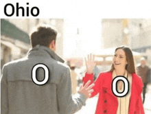 a man and a woman are standing next to each other on a street .