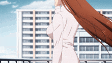 a woman with long brown hair is standing in front of a tall building