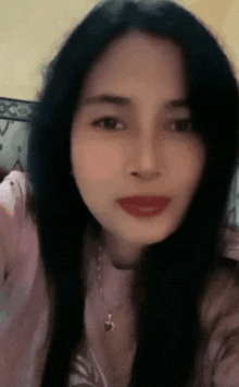 a close up of a woman 's face with long black hair and red lips