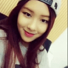 a close up of a woman wearing a hat and smiling for the camera .