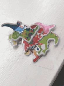a stack of colorful dinosaur puzzles on a table