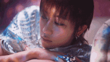 a close up of a woman 's face with her eyes closed and her hand on her face