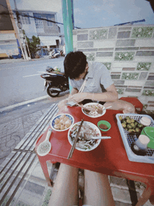 a man sits at a table eating a bowl of soup