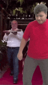 a man in a red shirt is dancing in front of a man in a white shirt