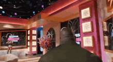 a man stands in a room with a sign that says ' zeus ' on it