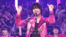 a man in a pink jacket singing into a microphone with the word baby on the bottom