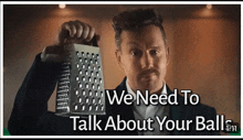 a man in a suit is holding a grater with the words we need to talk about your balls