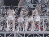 a group of women are standing on a stage in front of a crowd with a sign that says 24-23 on it