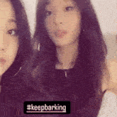 two young women are standing next to each other and looking at the camera with a sign that says `` keep barking '' .