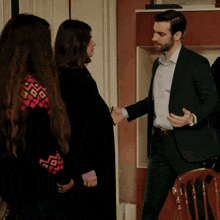 a man in a suit shakes hands with a woman