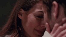 a close up of a woman kissing a man on the cheek