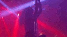a silhouette of a woman dancing on a pole in a club .