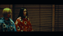 two women are holding guns and a knife in a dark room