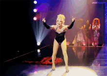 a woman in a black leotard is dancing on a stage with the words janeyjacke visible in the corner