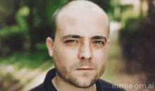 a bald man with a beard is looking at the camera with meme-gen.ai in the corner .
