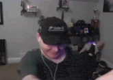 a man wearing headphones and a black hat with chinese writing