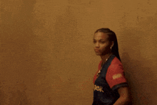 a woman wearing a red and blue nike shirt with graffiti written on it