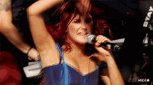 a woman with red hair singing into a microphone with rbd.gif written on the bottom
