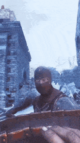 a man wearing a mask and helmet is standing in front of a brick building
