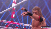 a man is wrestling another man in a wrestling ring on a television show .