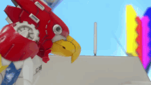a robot with a yellow beak has the letters cw on its chest