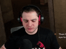 a man wearing headphones is sitting in front of a microphone in a dark room .