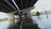 a group of people standing in the water under a bridge