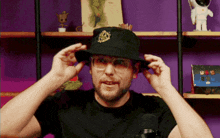 a man wearing a black hat with a gold emblem on the front