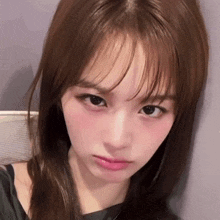 a woman with long hair and bangs looks at the camera