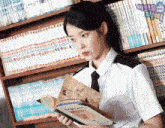 a girl is reading a book in front of a bookshelf that has a few books on it