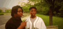 a couple of men are standing next to each other in a park .