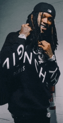 a man with dreadlocks is wearing a black hoodie that says paris on it